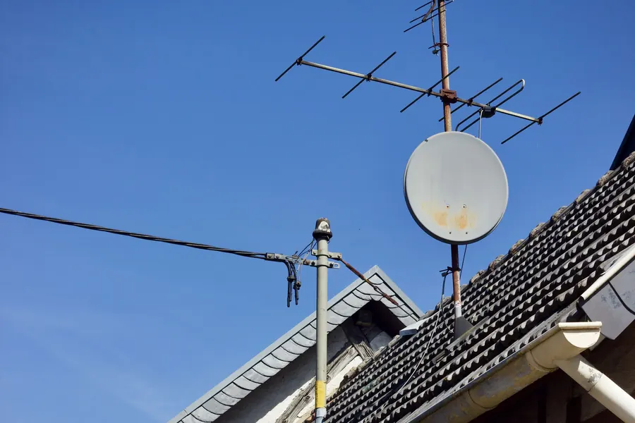 Antena TDT y antena parabólica instaladas en el tejado de una casa